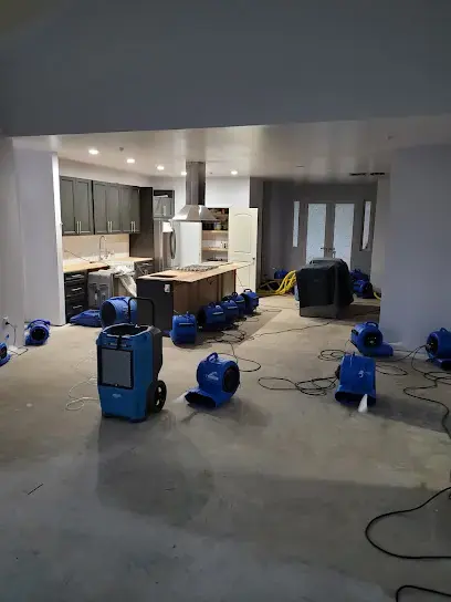 Air movers and dehumidifiers drying an open kitchen after a Redding water loss
