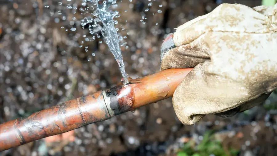 Water spraying from a split copper supply pipe in a Redding home