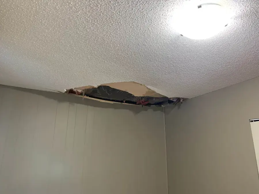 Ceiling drywall torn open by a water leak in a Redding home