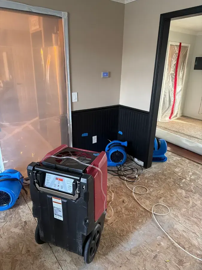 Dehumidifier and air movers drying a commercial room after a water loss